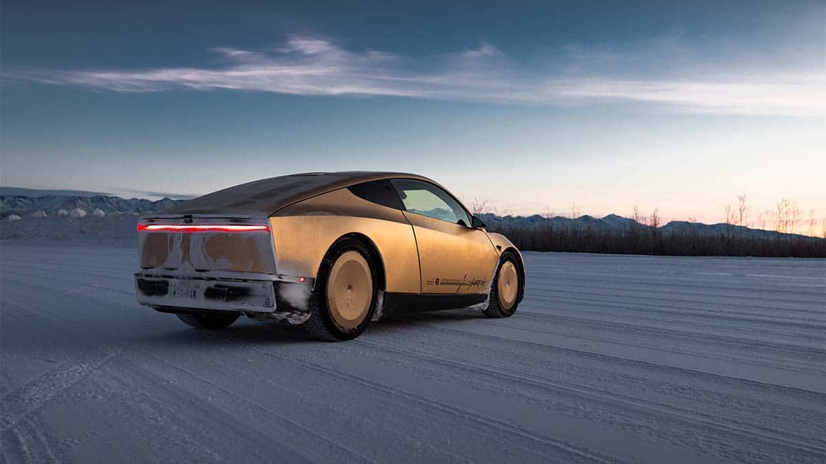 Coche eléctrico futurista recorriendo un paisaje nevado al atardecer en un entorno frío y tranquilo.